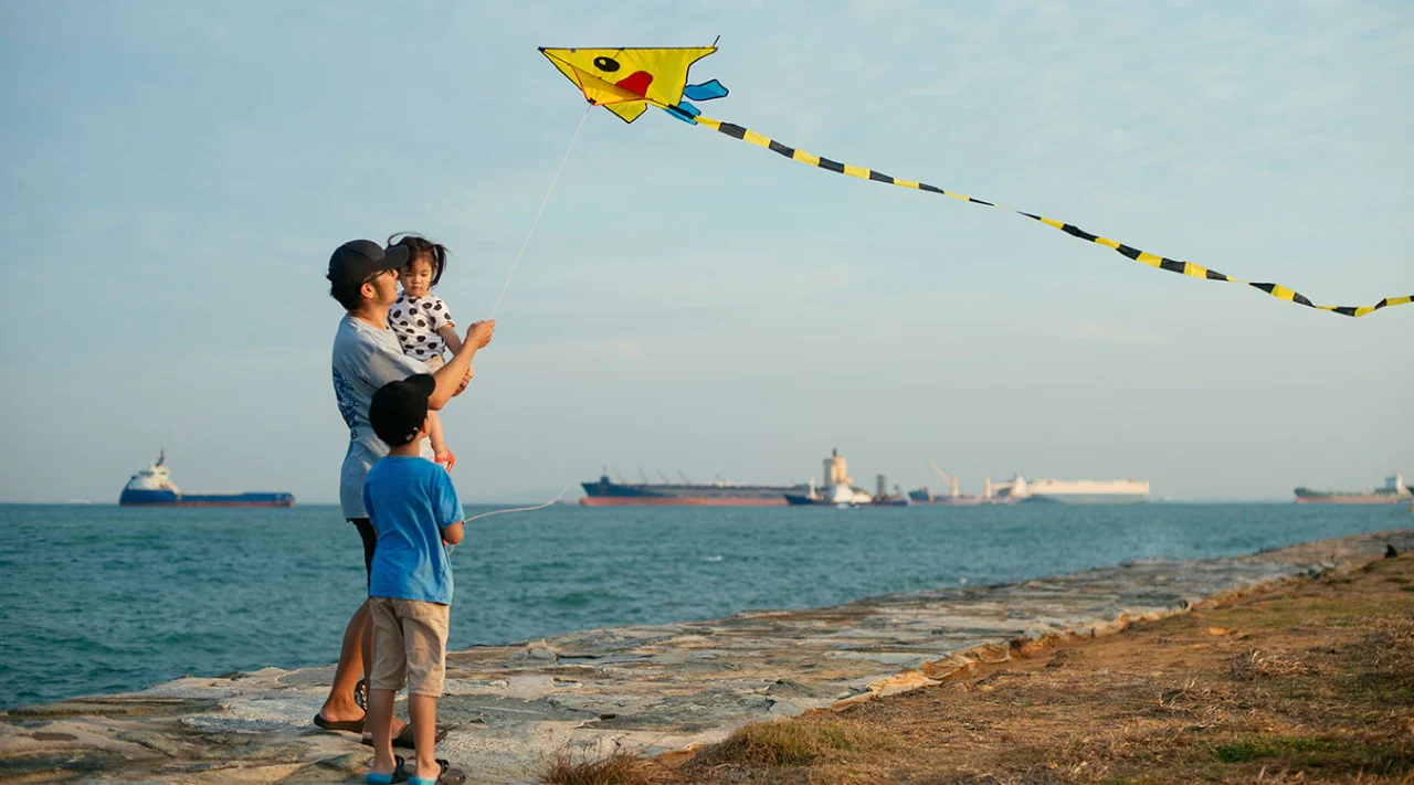 A family flying a kite on a Maritime beach.